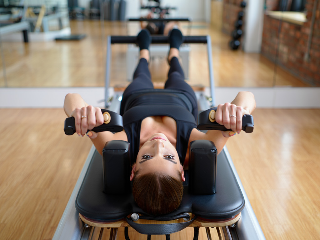 En person som tränar på en pilatesreformer